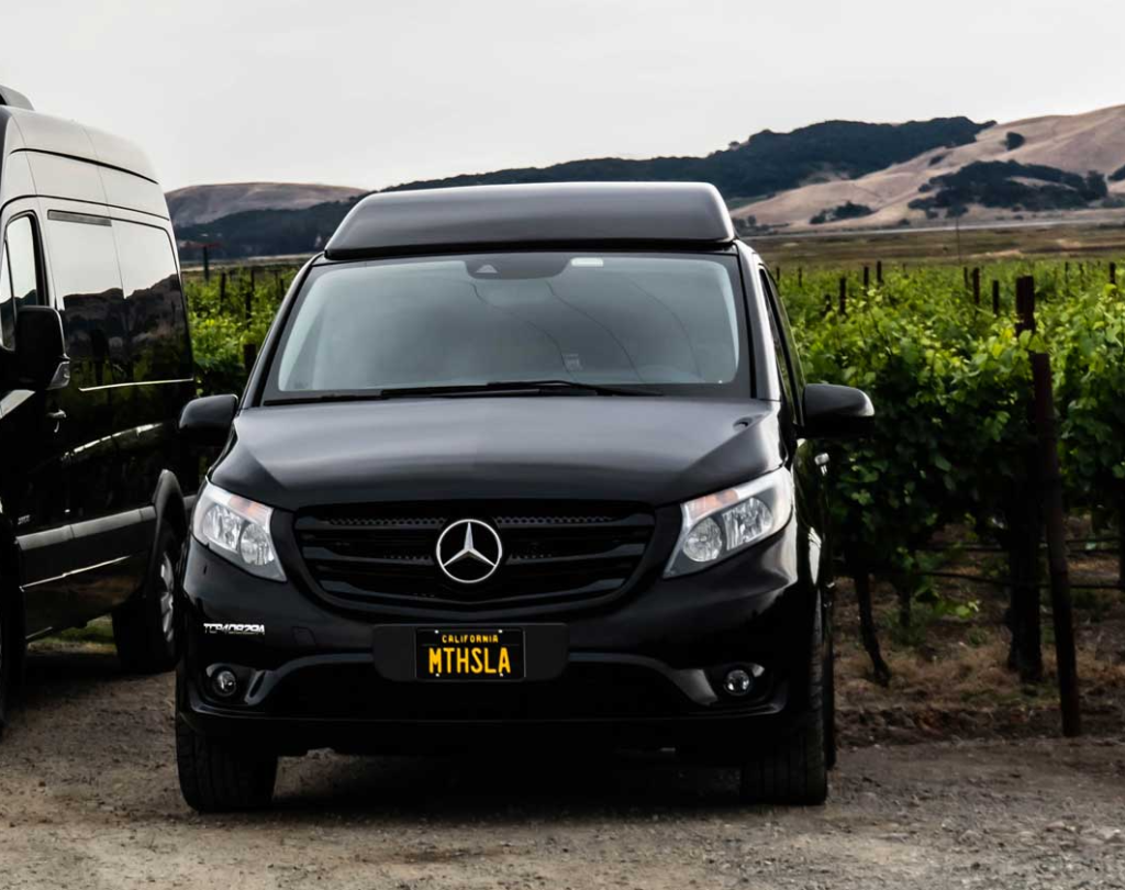 Photograph of a luxurious black Mercedes Metris parked in a vineyard.