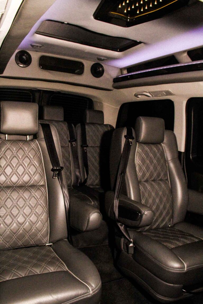 Photograph of the interior of Methuselah, featuring quilted leather captains chairs and a moon roof.